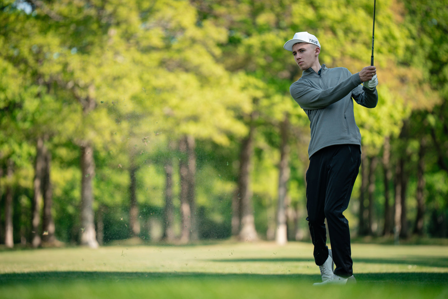 Golfer pitching in grey golf fleece